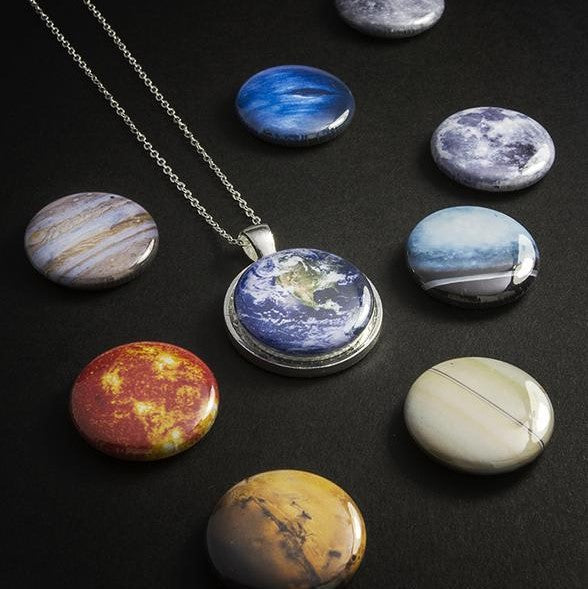 Planetary-themed jewelry set on a dark surface
