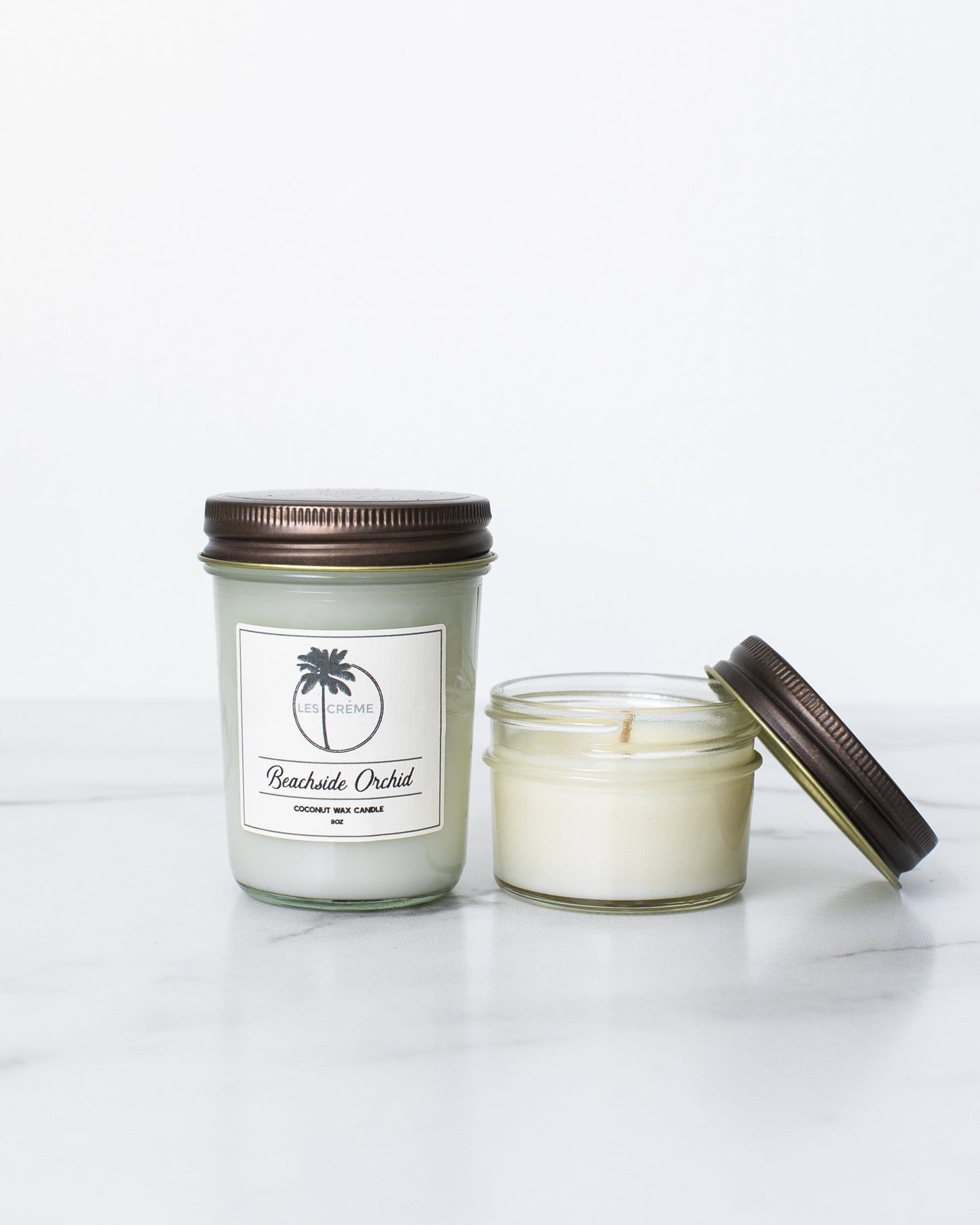 Two candles, one closed and one open, on a white background