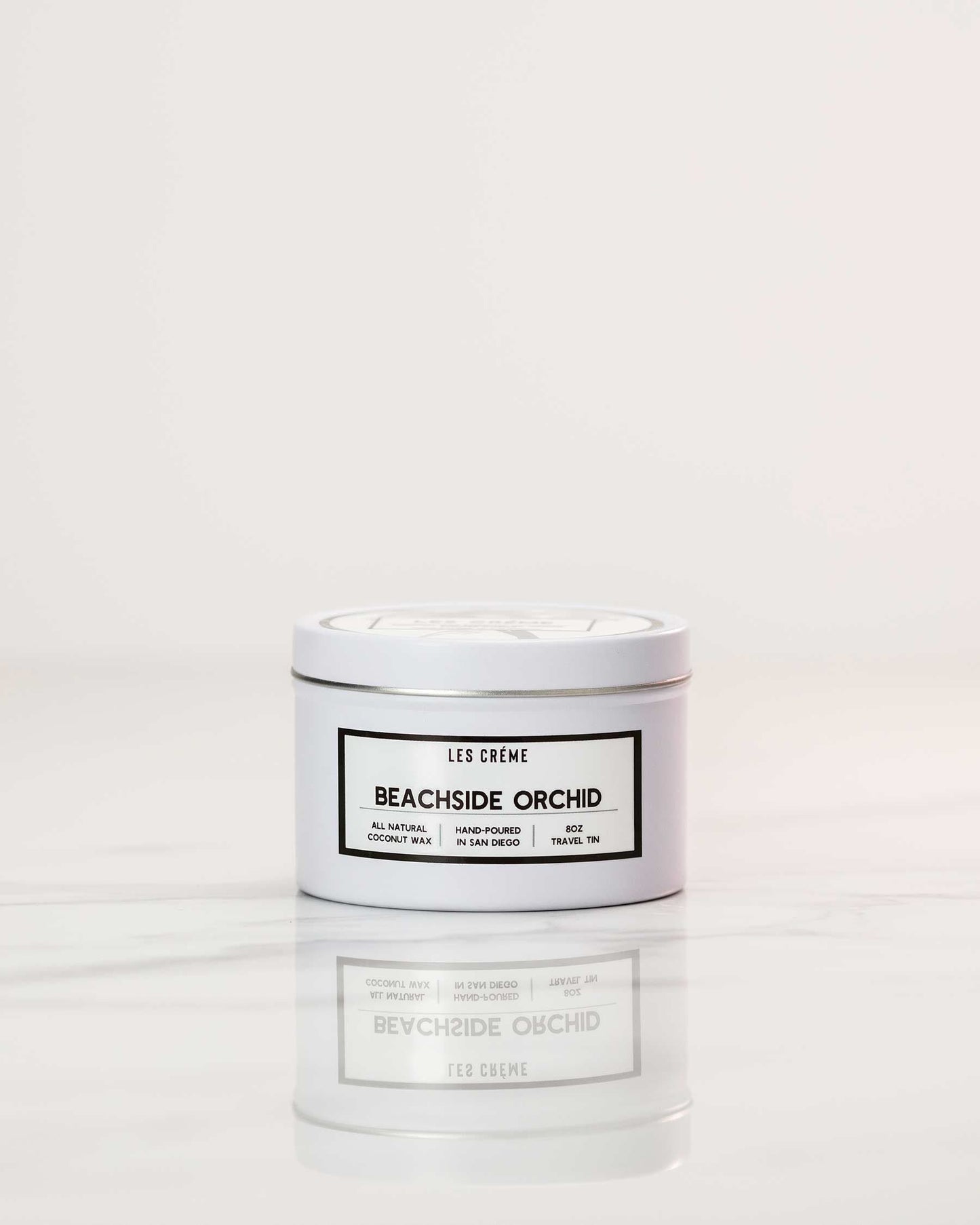 Candle jar labeled 'Beachside Orchid' by 'Les Creme' on a white background