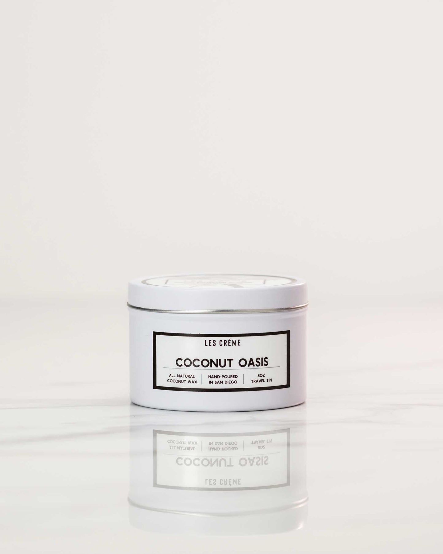 White candle labeled 'Coconut Oasis' on a white background