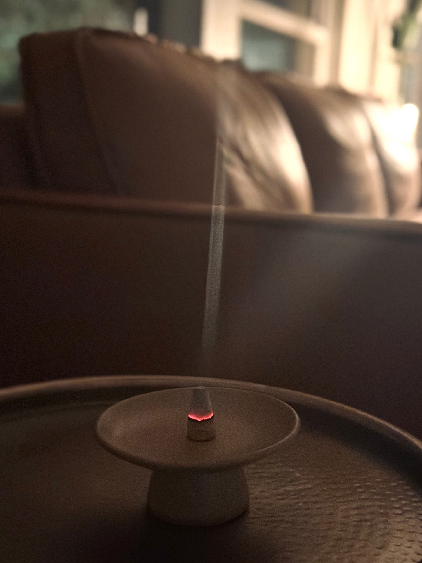 Incense burner with smoke on a table in a living room setting