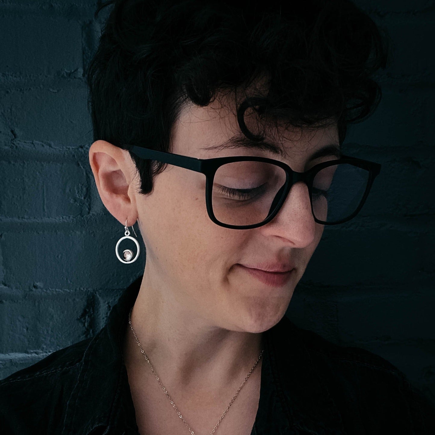 Person wearing glasses with a dark background