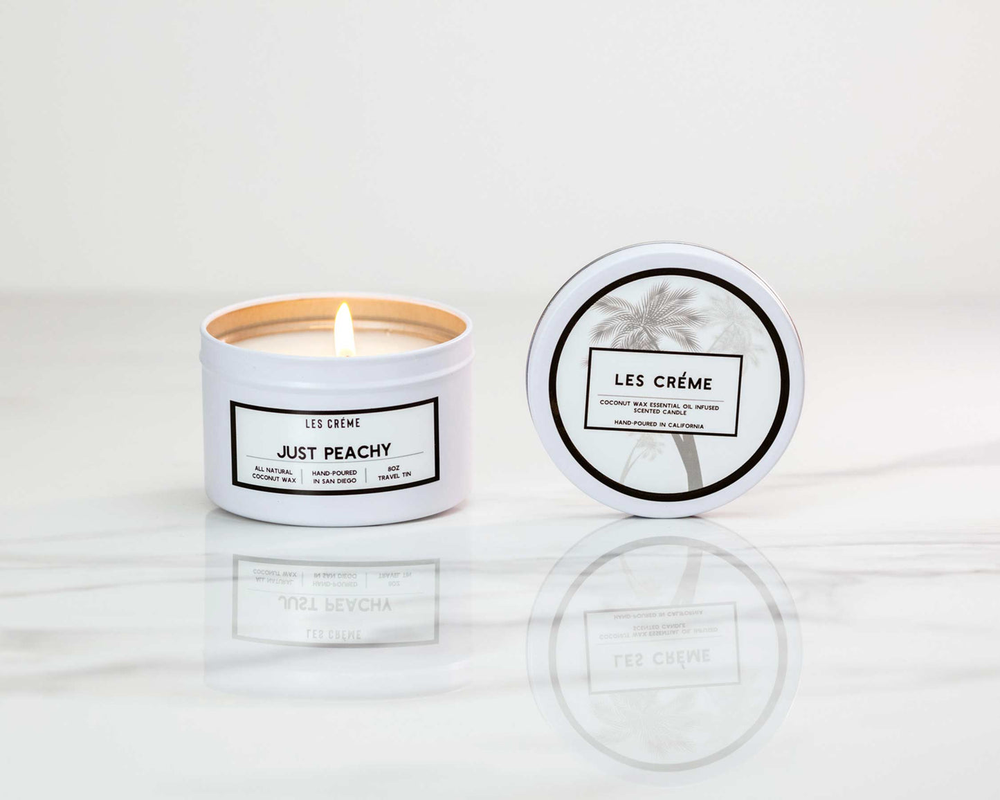 Les Crème candle labeled 'Just Peachy' with lid on a white background