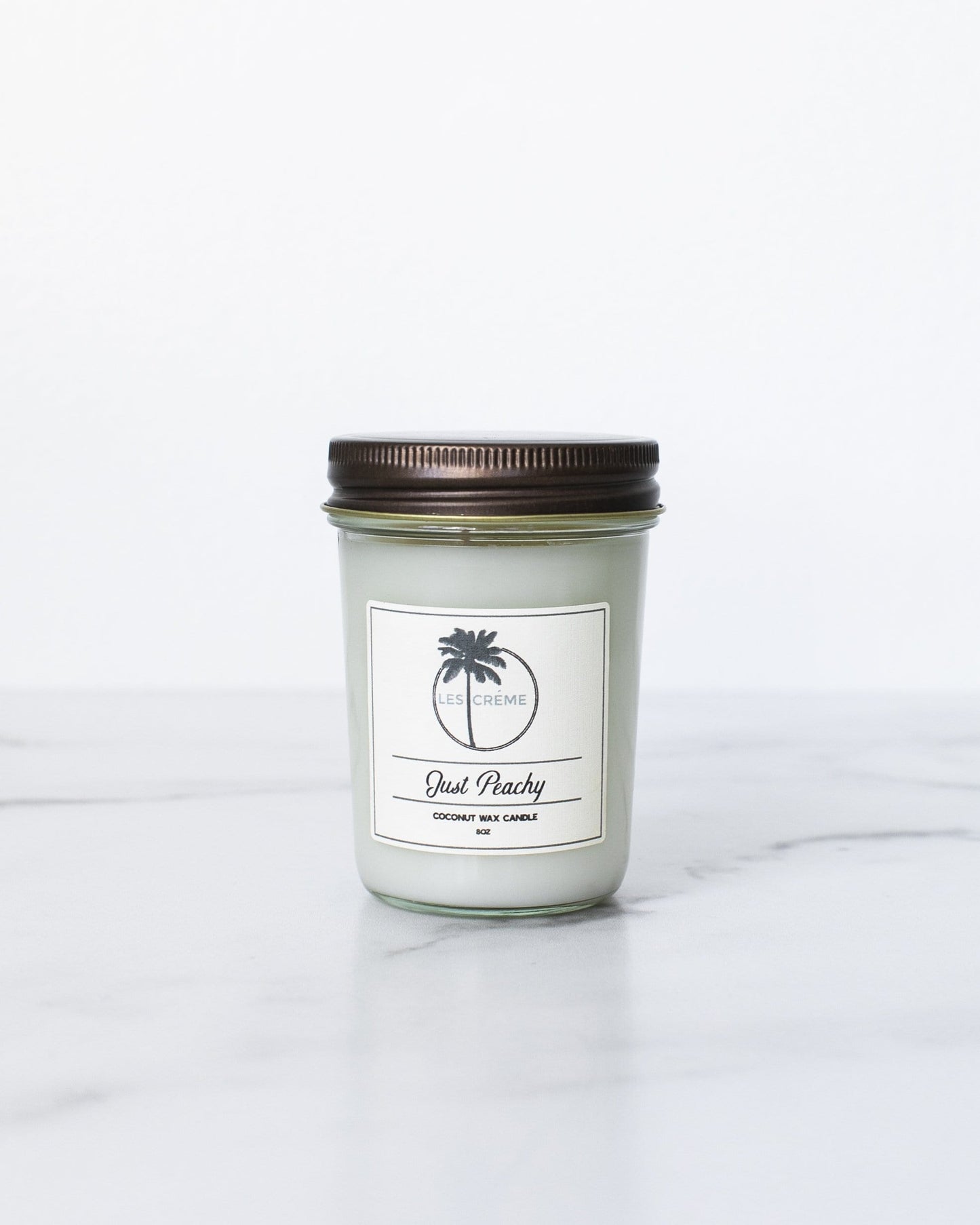 Candle in a glass jar with a brown lid on a white background