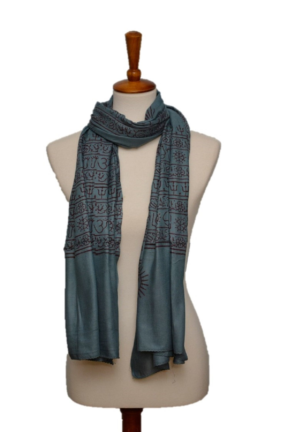 Teal patterned scarf on a mannequin against a white background