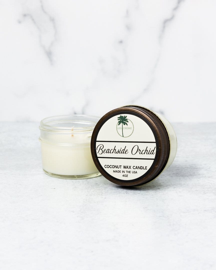 Coconut wax candle with a wooden lid labeled 'Beachside Orchid' on a marble surface.