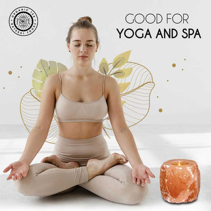 Woman in beige outfit meditating with a salt lamp and decorative elements on a light background