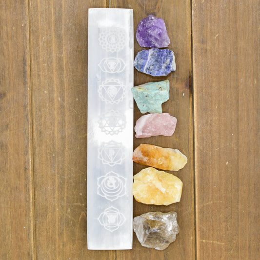 Set of colorful crystals and a white crystal grid on a wooden surface