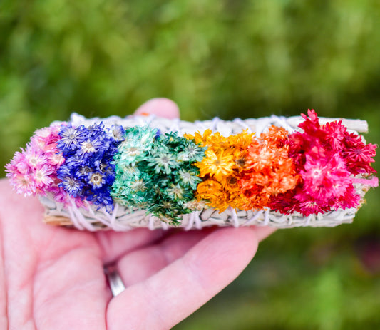 Colorful flower headband held by a hand with a blurred green background