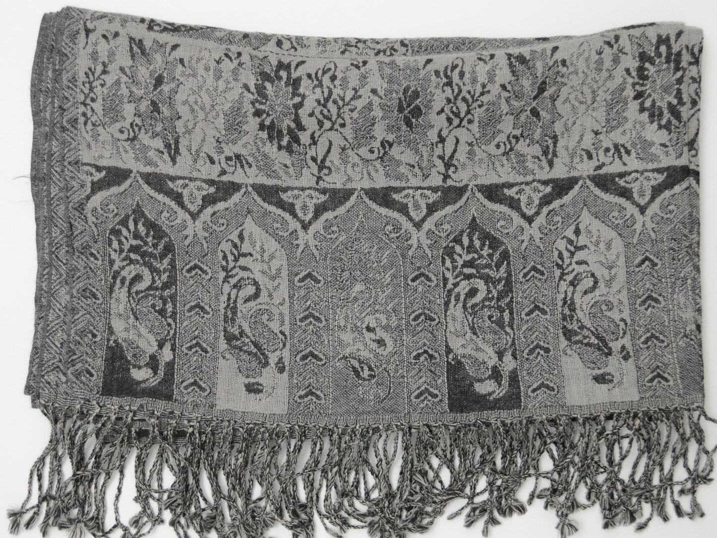 Textured fabric with paisley patterns and fringes on a white background
