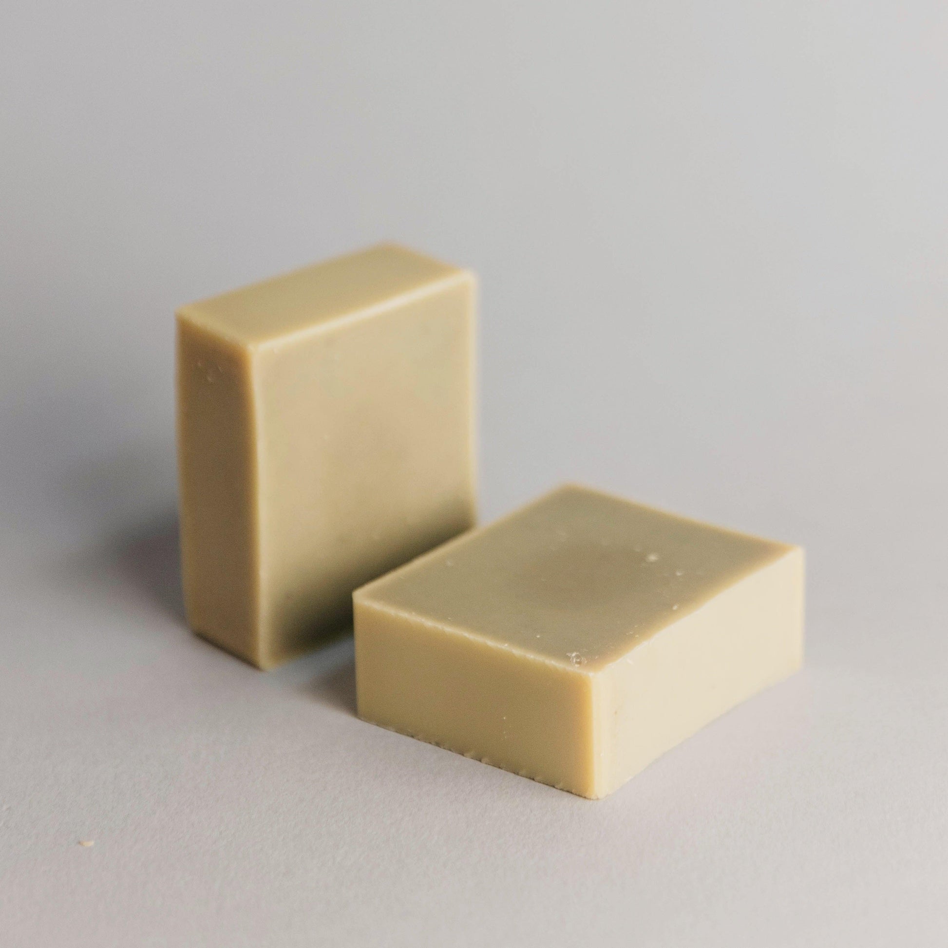 Two rectangular bars of soap on a gray background