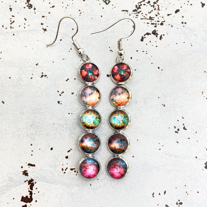 Multicolored round earrings on a textured white surface
