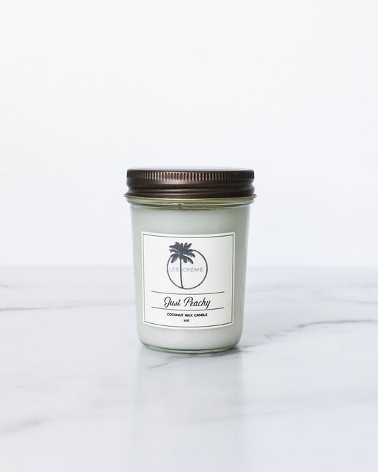Candle in a glass jar with a brown lid on a white background