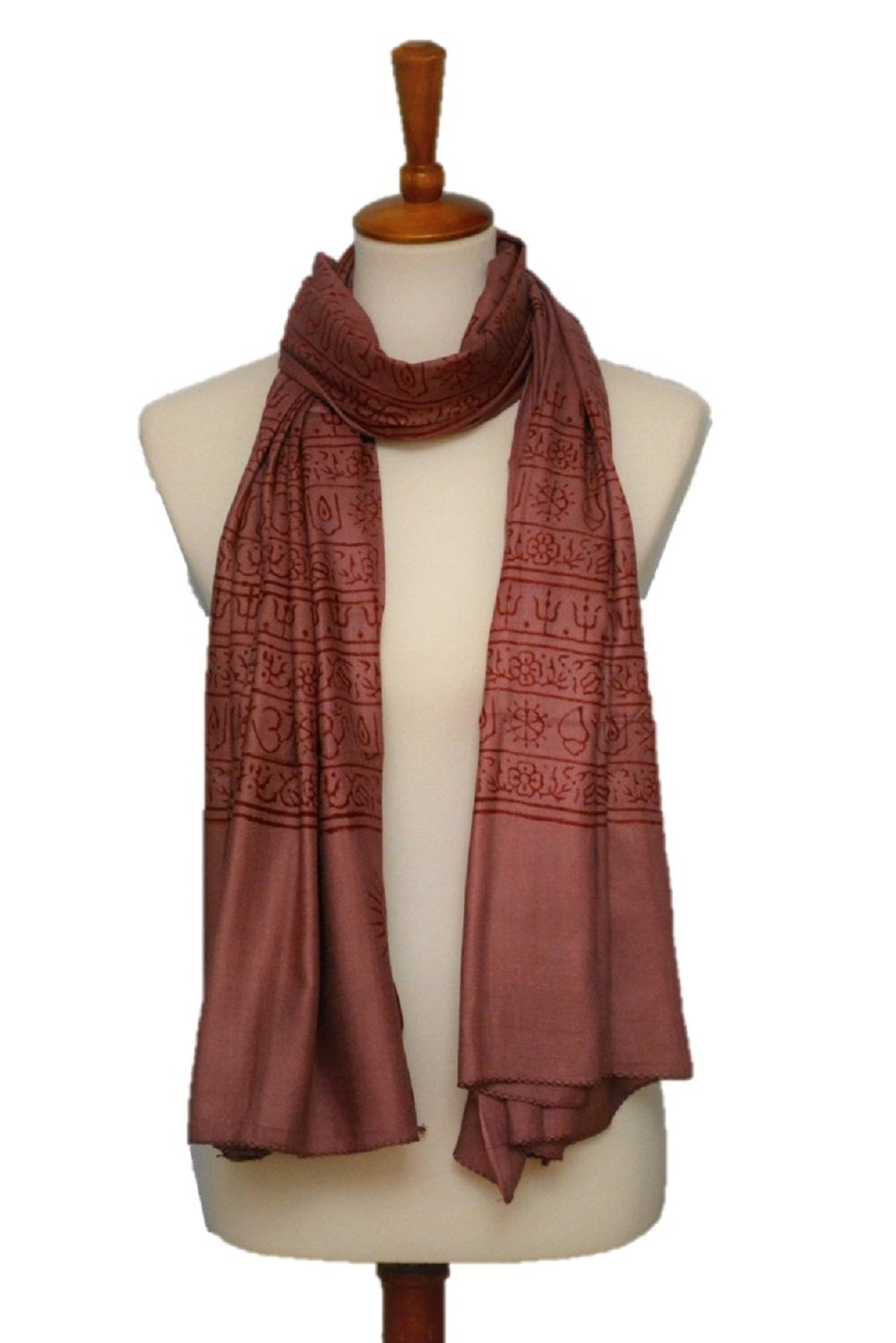 Brown patterned scarf on a mannequin against a white background