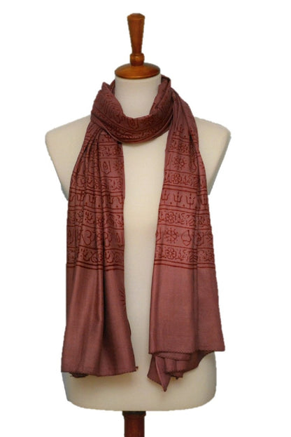 Brown patterned scarf on a mannequin against a white background