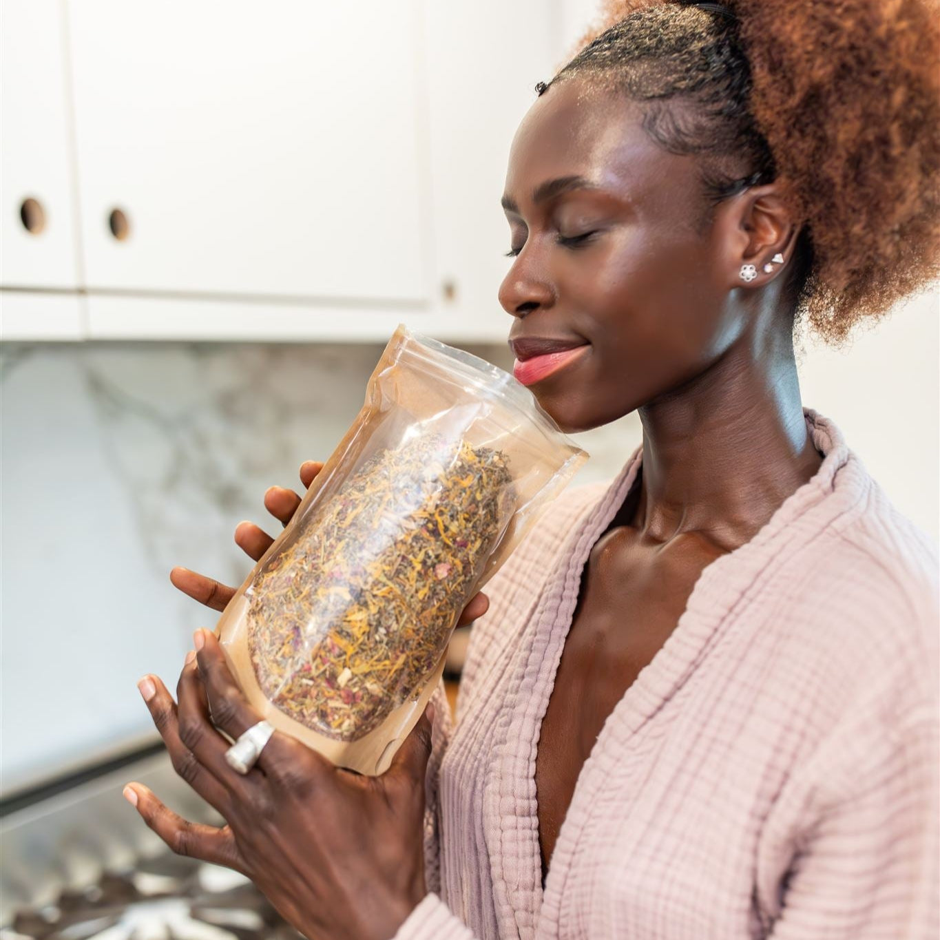 Woman holding a bag of herbs in a kitchen
