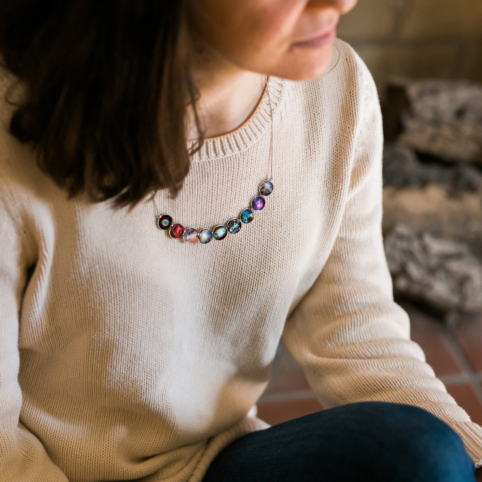 Person wearing a colorful beaded necklace with a neutral background