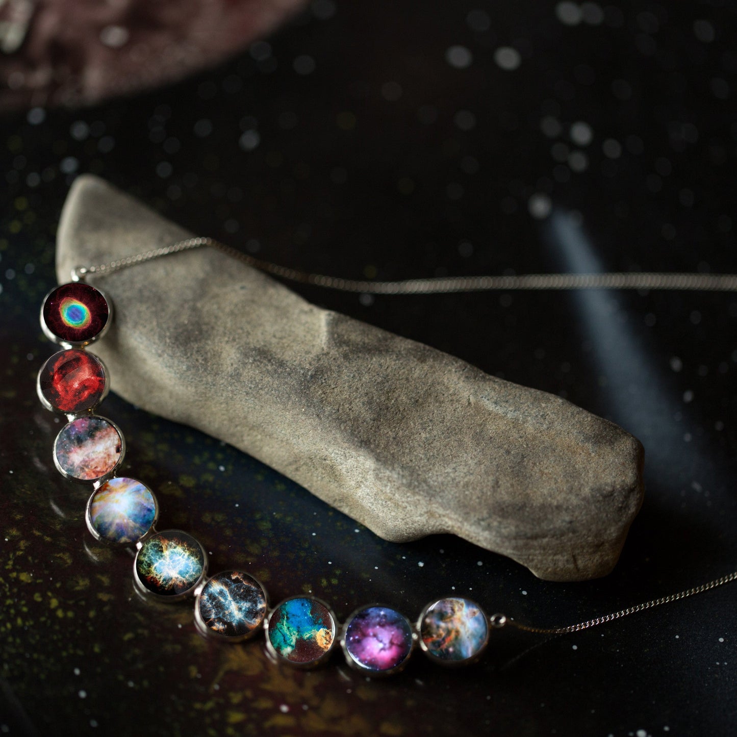 Necklace with galaxy-themed beads on a dark surface
