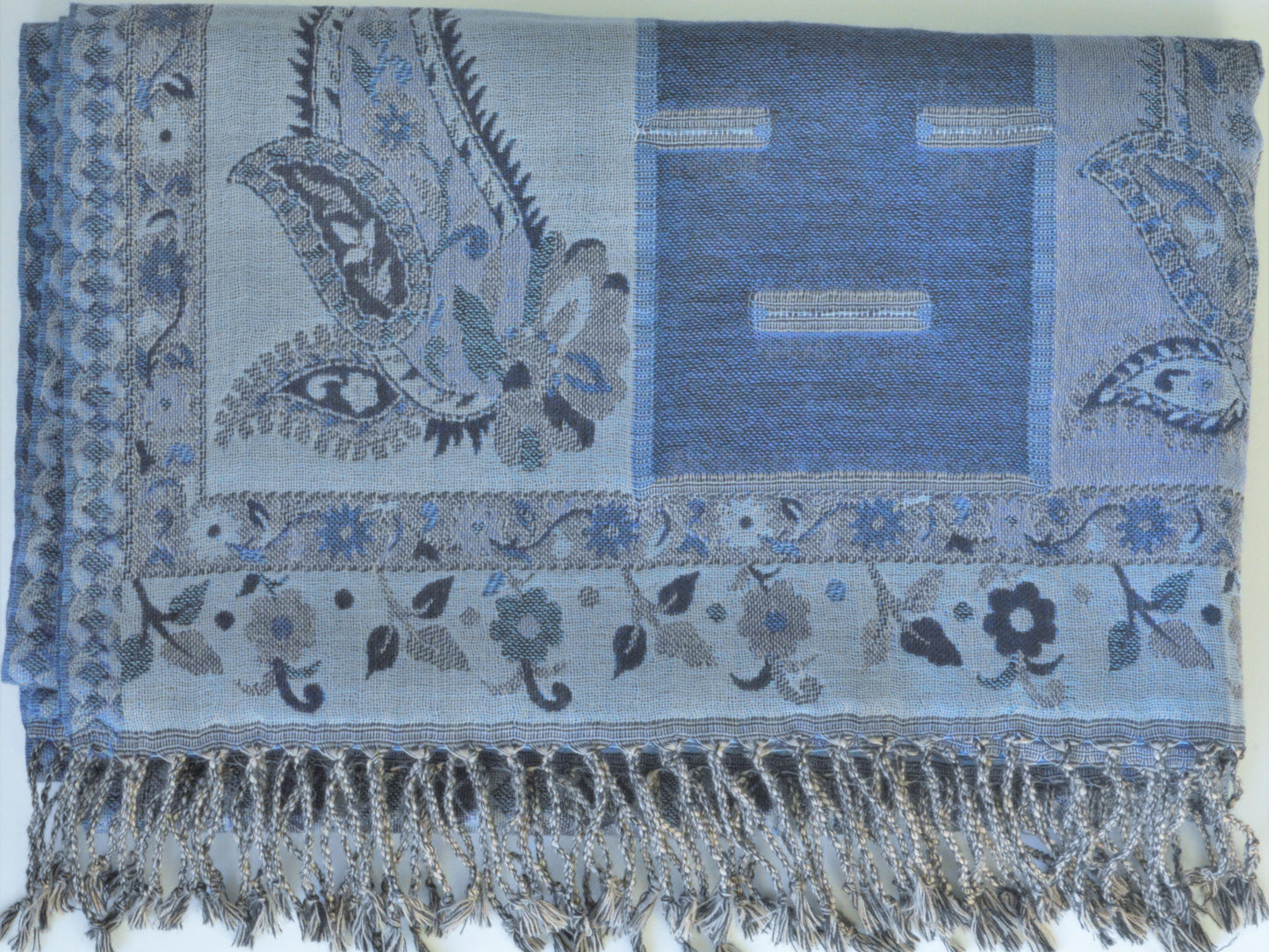 Blue patterned scarf with paisley designs and fringes on a white background