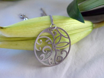 Silver necklace with a decorative pendant on a white background