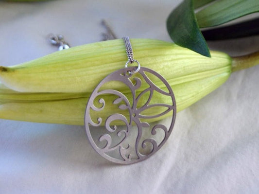 Silver necklace with a decorative pendant on a white background