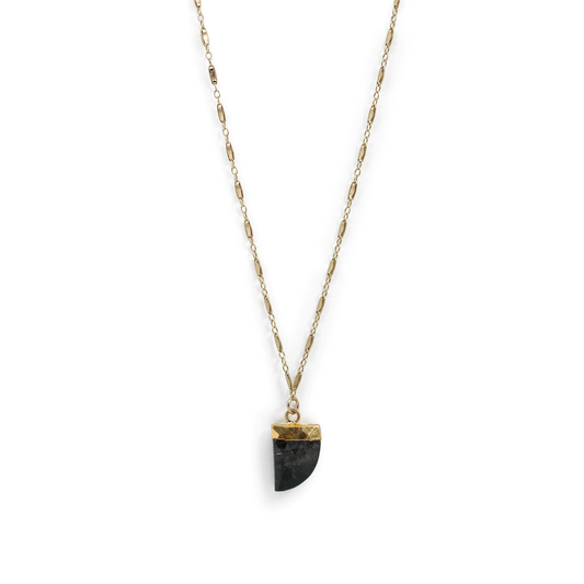 Necklace with a black pendant on a thin chain against a white background