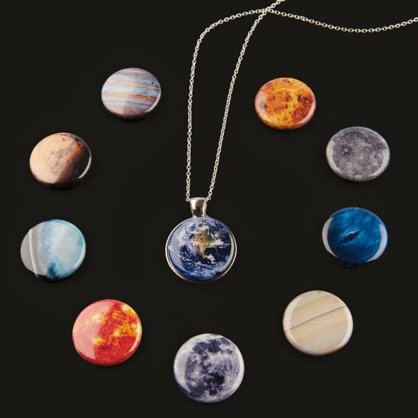 Necklace with a pendant shaped like Earth, surrounded by planet-themed buttons on a black background