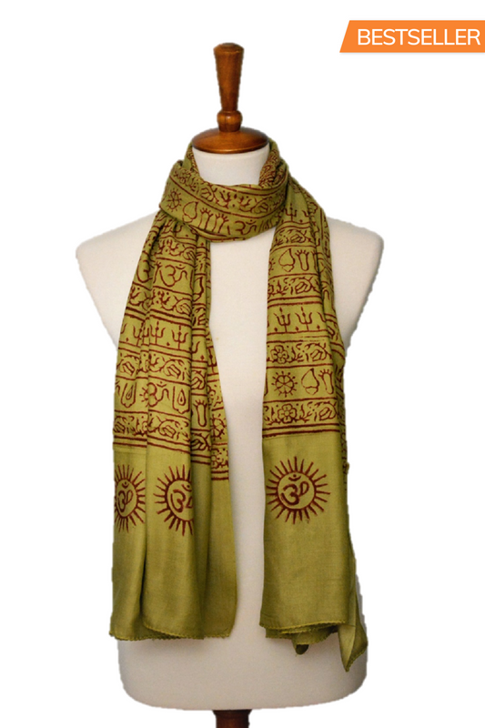 Green scarf with brown patterns on a mannequin against a white background