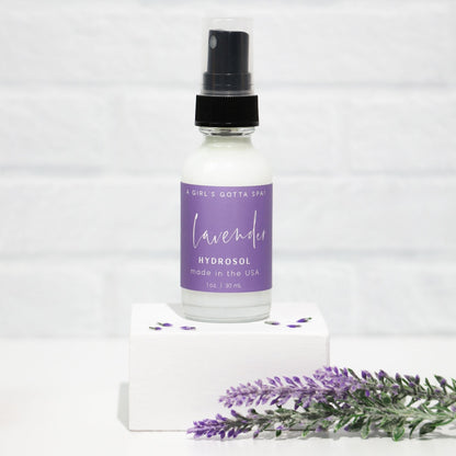 Lavender hydrosol bottle with a black spray top on a white background