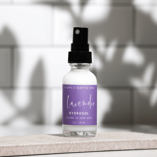 Bottle of lavender hydrosol with a purple label on a neutral background