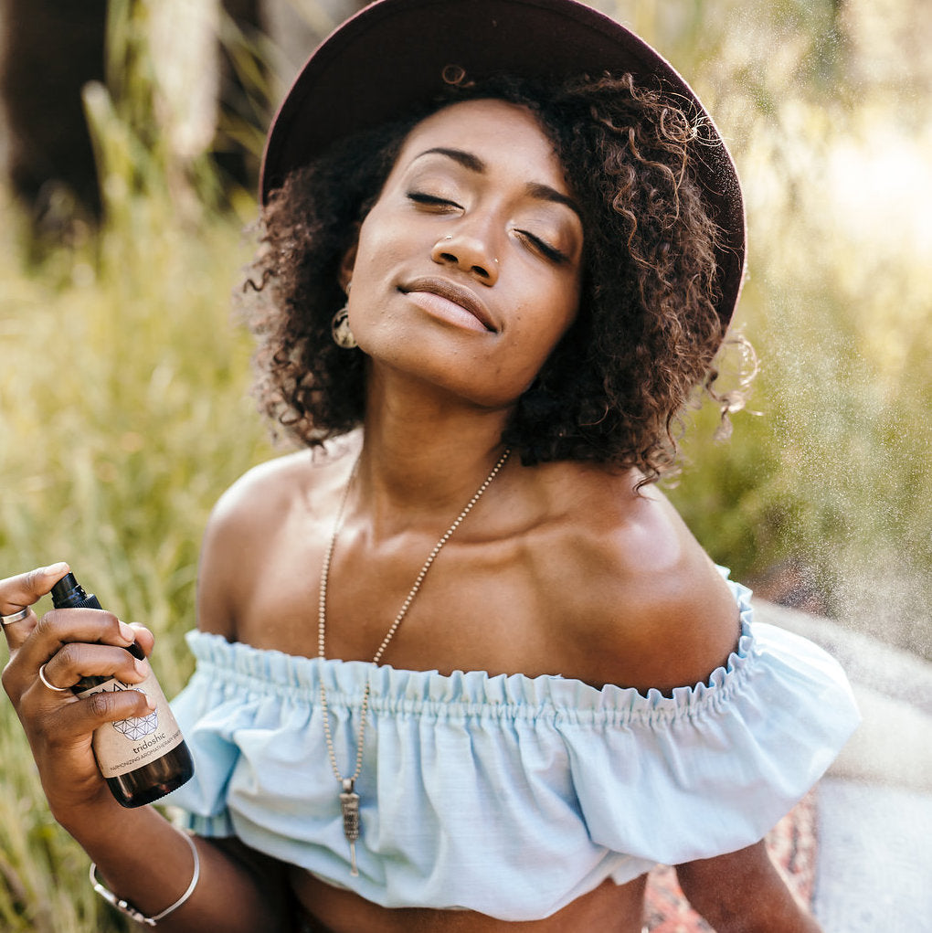 Woman applying sunscreen outdoors in a natural setting