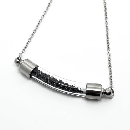 Silver necklace with a cylindrical pendant on a white background