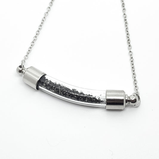 Silver necklace with a cylindrical pendant on a white background